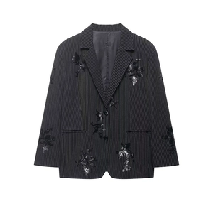 Detailed close-up of black pinstripe blazer with elegant silver sequin embroidery work