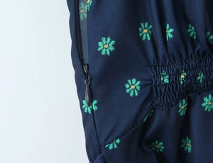 Detailed macro view of invisible back zipper and elastic smocking on floral print dress