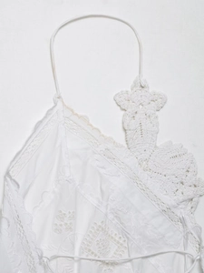 Detail of white crochet flower embroidery and lace stitching on halter top