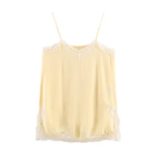 Detail of light yellow silk camisole featuring delicate white lace trim on the V-neckline