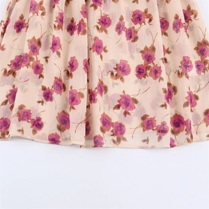 Detailed macro view of beige floral chiffon shirt hem with pink rose patterns