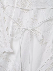 Close-up of white cotton blouse with floral embroidery and delicate lace details