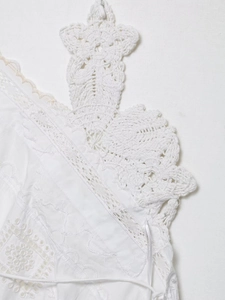 Detailed macro view of white cotton fabric with floral crochet lace and eyelet embroidery