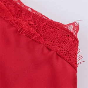 Detailed macro view of smooth red satin fabric with delicate eyelash lace trim edges