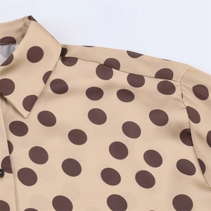Detailed close-up of a satin polka dot blouse collar with premium smooth silk texture
