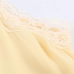 Close-up of delicate floral lace neckline on light yellow chiffon sleeveless top