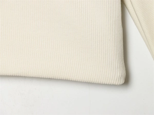 Gros plan de la texture en maille côtelée crème sur le sweat-shirt coupe décontractée