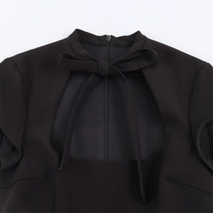 Vue détaillée d'une robe noire avec découpe carrée au dos, nœud délicat et fermeture éclair