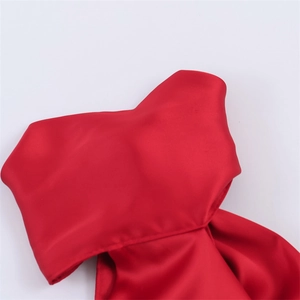 Detailed view of red satin fabric featuring a smooth glossy finish and stitched edge detail