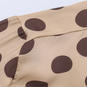 Detail of khaki satin fabric with brown polka dots and high-quality stitching craft
