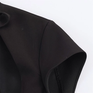 Gros plan détaillé sur la couture d'épaule et la texture du tissu de la robe noire