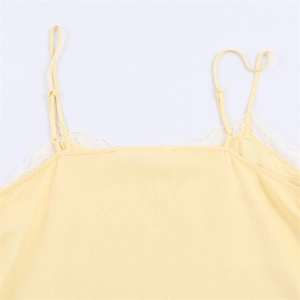 Detail of pale yellow camisole showing delicate white lace trim and adjustable thin straps