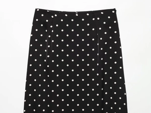 Detail showing high-waist black polka dot skirt with seamless invisible zipper and stitching