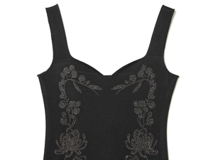 Détail de la robe midi noire avec décolleté en V et élégantes fleurs en strass argentés