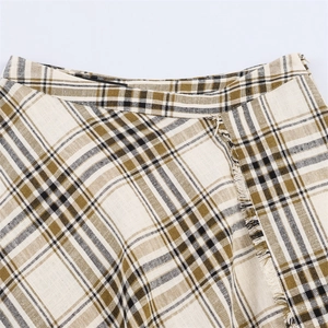 Detail shot of the beige plaid pattern and fringe hem on this asymmetric mini skirt