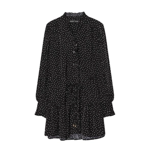 Detailed flat lay of black polka dot dress featuring stand collar and waist drawstring