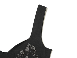 Vue macro d'une robe en tricot noir avec des détails en strass argentés au col