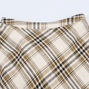 Macro detail of high-waisted plaid skirt showing brown woven texture and pattern