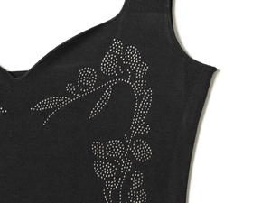 Détail du décolleté en cœur et du motif floral en strass sur la robe noire