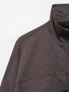 Close-up of dark grey textured bomber jacket featuring refined stand collar and premium fabric