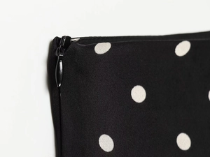 Detail shot of a black polka dot skirt featuring a hidden zipper and high-quality stitching