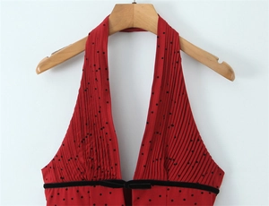 Détail du haut dos nu à pois rouges avec poitrine plissée et nœud en velours noir