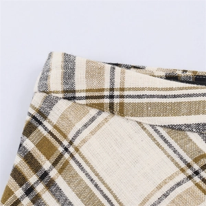 Close-up of the beige plaid skirt featuring thick woven texture and waistline detail
