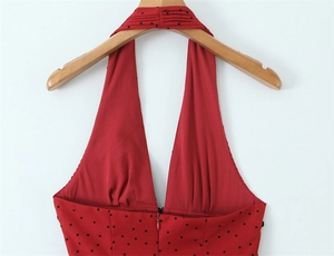 Détail d'une robe rouge à pois avec décolleté licou en V et fermeture éclair invisible