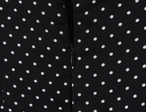 Détail de la robe à pois noir et blanc avec une fermeture éclair invisible lisse au dos