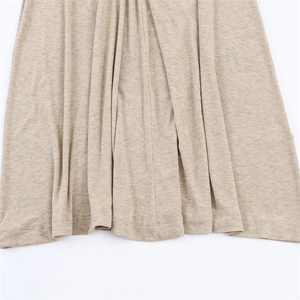 Detailed macro shot of oatmeal knit fabric featuring pleated hemline on maxi dress