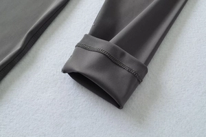 Detailed close-up of high-elasticity fabric with reinforced stitching on the dark grey jumpsuit