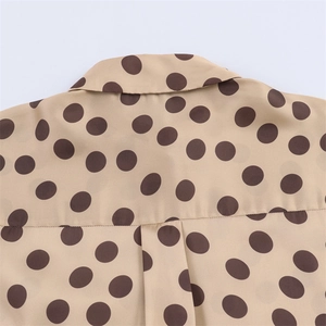 Women's apricot satin blouse with brown polka dots featuring a classic lapel collar