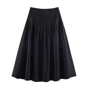 Detail of elegant black pleated midi skirt showing rich fabric texture and A-line silhouette