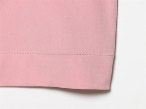 Detailed close-up showing fine stitching and twill texture on pink casual pants