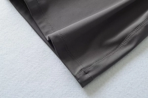 Detail of professional double-needle stitching on grey elastic fitness jumpsuit fabric