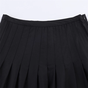 Detail of black pleated skirt featuring high-waisted cut and hidden side zipper closure