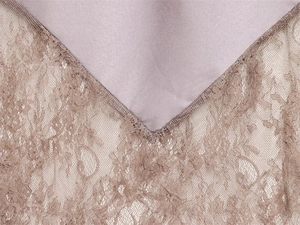 Detail von lavendelfarbenem Satinstoff mit aufwendiger brauner floraler Spitzenkante