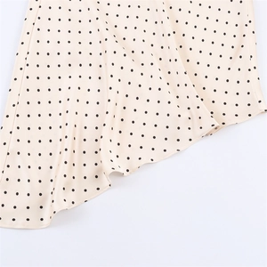 Detail of polka dot print skirt featuring an elegant asymmetrical ruffled hemline