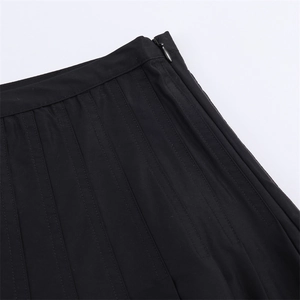 Close-up of invisible side zipper and precise pleat stitching on black pleated skirt