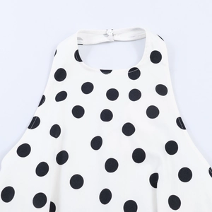 Detail of halter neck closure with white buttons on black and white polka dot top