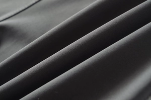 Close-up of the high-density matte dark gray fabric texture on the slim jumpsuit