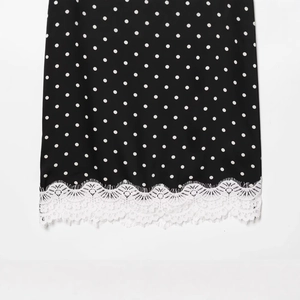 Black polka dot midi skirt featuring elegant white eyelash lace trim at the hemline