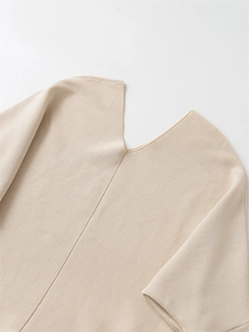Detail view of V-neckline and fine texture on a minimalist beige knitted sweater for women