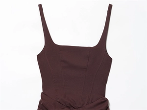 Detail of burgundy sleeveless square neck dress showing tailored seams and waist ruching