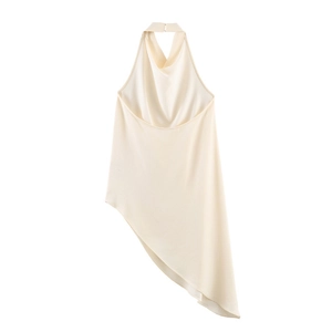 Détail du haut dos nu crème montrant l'ourlet asymétrique et la texture soyeuse du tissu