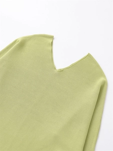 Detail view of a V-neck lime green knitted top showing soft texture and fine fabric weave