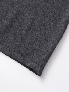 Makroaufnahme von dunkelgrauem Strickstoff mit feiner Textur und sauberem Saumabschluss