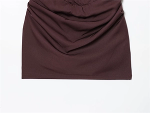 Detail of burgundy knitted dress featuring side ruching and precise seam stitching