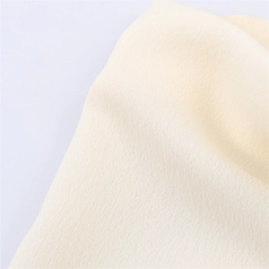 Gros plan sur la texture du tissu en maille crème avec des détails de tissage délicats