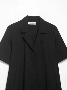 Détail du col de chemise en popeline noire avec boutons et finitions sur la manche